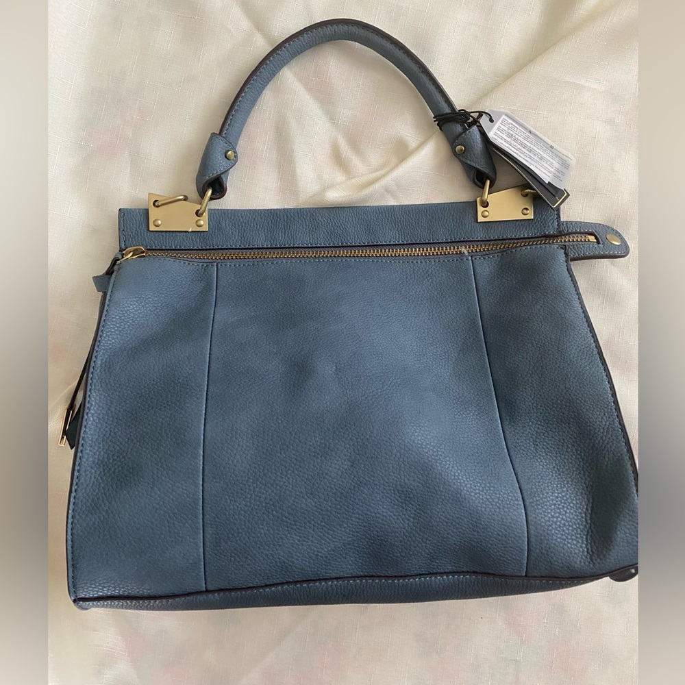 Blue satchel bag with front pocket.  Long strap included with bag.